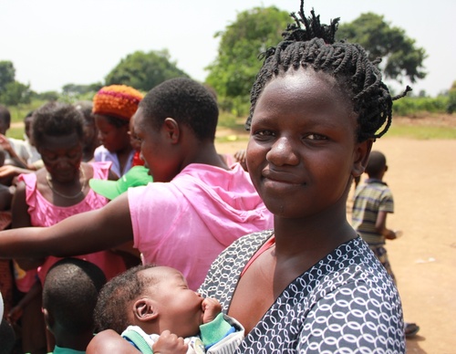 Eine Mutter steht mit ihrem Säugling in einer Schlange in Nkumba, dem Zielort des Ugandahilfeprojektes.