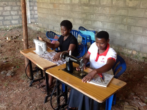 Zwei Schülerinnen lernen an Nähmaschinen in der Handwerksschule St.Dennis, kurz nach der Eröffnung 2015
